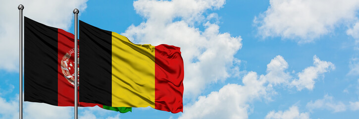 Afghanistan and Belgium flag waving in the wind against white cloudy blue sky together. Diplomacy...