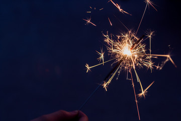 Obraz premium someone holding a sparkling firework in backyard at night on the 4th of july 