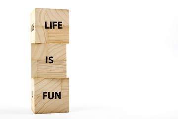 Wooden cubes with the inscription life is fun on a white background