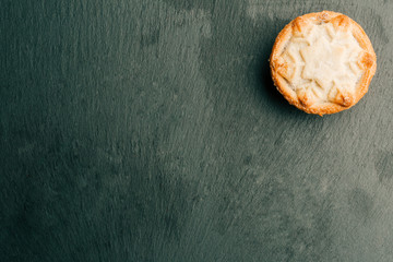 Homemade mince pie on the black slate background