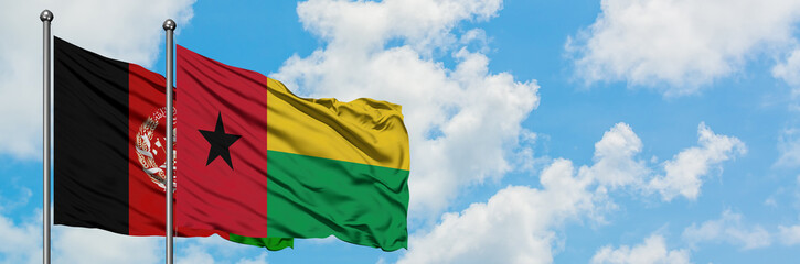 Afghanistan and Guinea Bissau flag waving in the wind against white cloudy blue sky together....