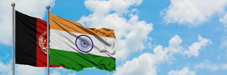Afghanistan and India flag waving in the wind against white cloudy blue sky together. Diplomacy...