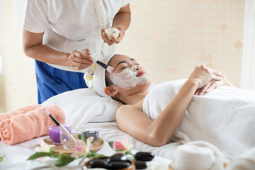 Obraz na płótnie Canvas Beautiful Asian woman in mask on face in spa beauty salon, enjoying and relaxing time, skin care and healthcare concept