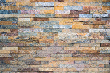 Decorative texture of a beautiful wall with rectangular parts of multi-colored artificial stone...