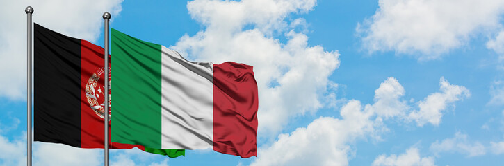 Obraz premium Afghanistan and Italy flag waving in the wind against white cloudy blue sky together. Diplomacy concept, international relations.