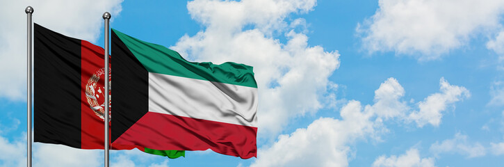 Afghanistan and Kuwait flag waving in the wind against white cloudy blue sky together. Diplomacy...