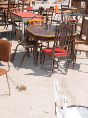 Fototapeta na wymiar different vintage street tables and chairs in a cafe outdoor second hand