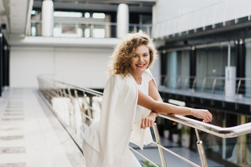 Modern businesswoman. Beautiful young woman looking at camera with smile while standing at the clothing store.