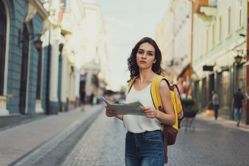 Young beautiful female traveler lost in the city. Beautiful architecture. an old-fashioned street.