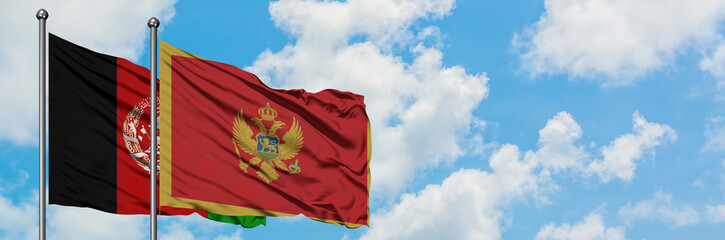 Afghanistan and Montenegro flag waving in the wind against white cloudy blue sky together....