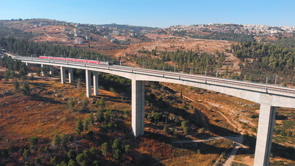 Train on large bridge aerial Drone footage of red train over Railway bridge in Jerusalem