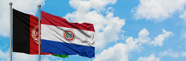 Afghanistan and Paraguay flag waving in the wind against white cloudy blue sky together. Diplomacy concept, international relations.