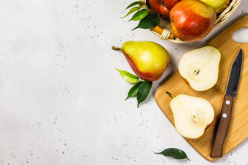 Ripe colourful pears sliced on cutting board. Top view, space for text.