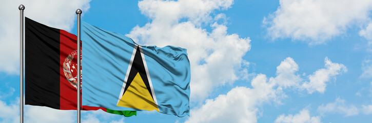 Afghanistan and Saint Lucia flag waving in the wind against white cloudy blue sky together....