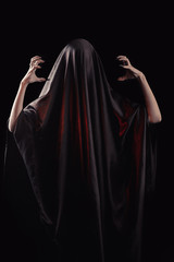 Naklejka premium a woman covered with black cloth with a closed face suffers. faceless pain. long black nails on thin female fingers. emotion without facial expressions