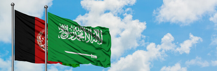 Afghanistan and Saudi Arabia flag waving in the wind against white cloudy blue sky together....