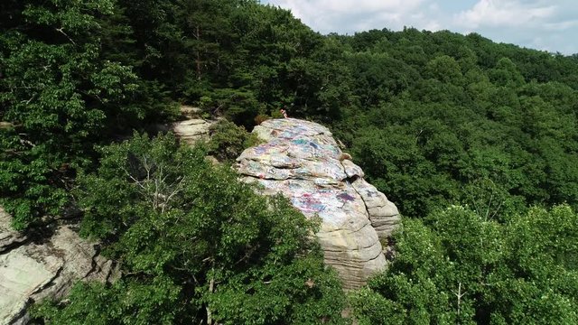 People sit on Graffiti Rock in rural Kentucky, aerial