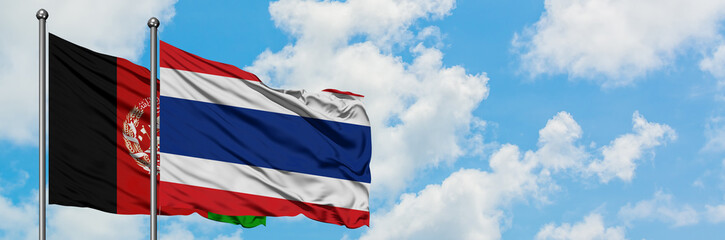 Afghanistan and Thailand flag waving in the wind against white cloudy blue sky together. Diplomacy...