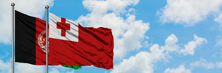 Afghanistan and Tonga flag waving in the wind against white cloudy blue sky together. Diplomacy concept, international relations.