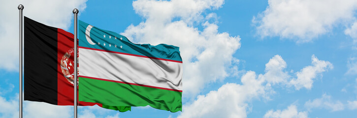 Afghanistan and Uzbekistan flag waving in the wind against white cloudy blue sky together....