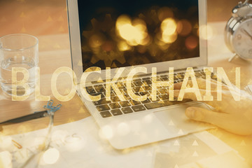 Blockchain theme hologram with man working on computer on background. Concept of crypto chain. Double exposure.