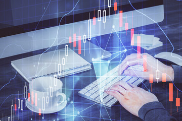 Multi exposure of graph with man typing on computer in office on background. Concept of hard work.