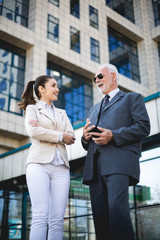 An older man and a young colleague are talking about work