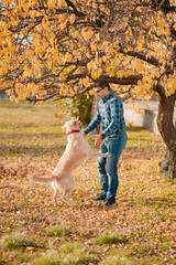 Fototapeta premium female with dog golden retriever having fun on autumn vacation.