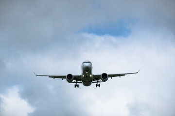 Airplane in landing approach with dark cloudscape