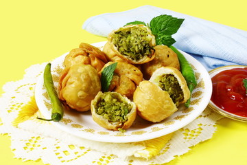 traditional indian gujarati food snack kachori,vegetable stuffed balls or patties with tomato sause,yellow background top view