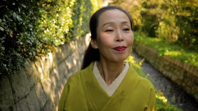 Elegant Japanese woman enjoying a park in Kyoto Japan.