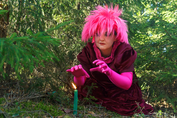 A young sorceress in purple clothes conjures a candle dug into the ground.