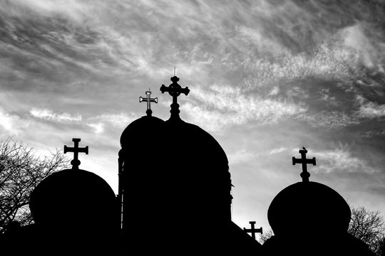 Silhouette of Church domes with a cross at sunset in Black and White