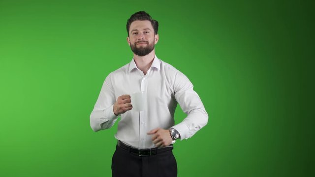 young beautiful happy man thums up isolated on green. Like. Happiness. With a cup in his hand.