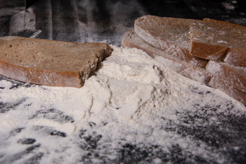 Flour and bread on a wooden board. Food preparation. 