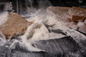 Flour and bread on a wooden board. Food preparation. Slow motion.