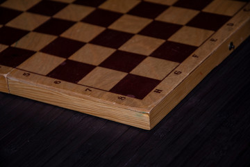 Wooden chess board on black background.