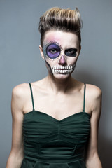 Halloween. Beautiful woman with bright black halloween makeup isolated over gray background