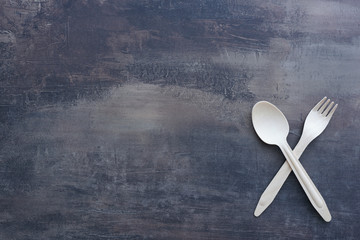 Top view of marble kitchen benchtop with wooden cutlery - crossed fork and spoon. Copy space for menu.