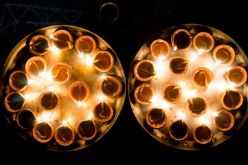 Macro shots of diyas being lit by hand or candle for the hindu religious festival of Diwali.