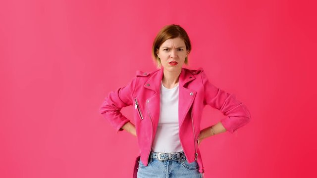 Ew. Ick, yuck. Woman on pink background looking at the camera and feeling disgusted. 