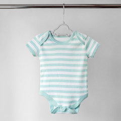 Striped clean clothes for a newborn on a hanger. The concept of clothes, motherhood, newborn.