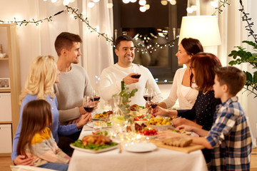 celebration, holidays and people concept - happy family having dinner party, drinking red wine and toasting at home