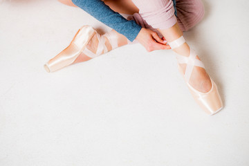 Legs of a ballerina in pointe shoes close-up on a white background top view