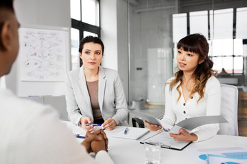 new job, hiring and employment concept - international team of recruiters having interview with...