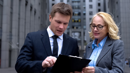 Business partners analyzing sales report document together, project cooperation