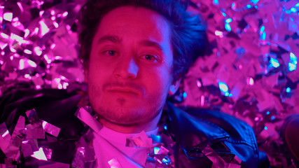 Drunk guy crying on floor at party, empty eyes staring at camera, alcoholism