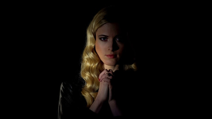 Obraz premium Female sinner praying in dark room, looking for forgiveness, faith and belief