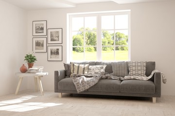 Stylish room in white color with sofa and summer landscape in window. Scandinavian interior design. 3D illustration