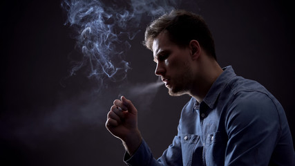 Upset man exhaling smoke, harmful unhealthy habit concept, tobacco industry